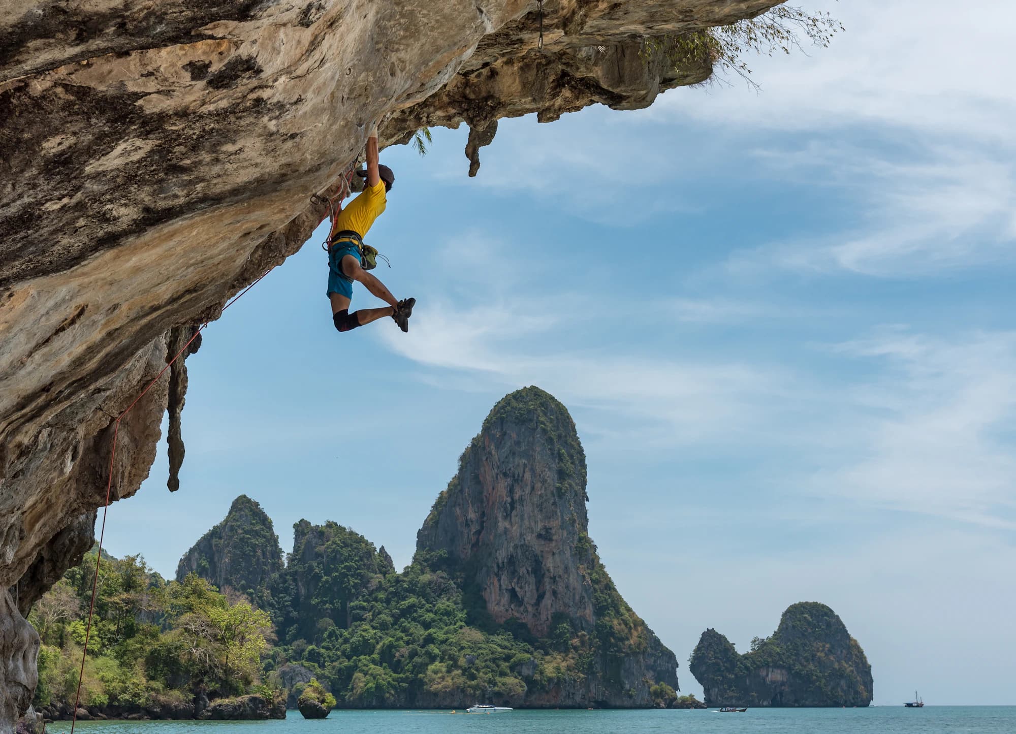 Climber on an open granite face under a wide pale sky